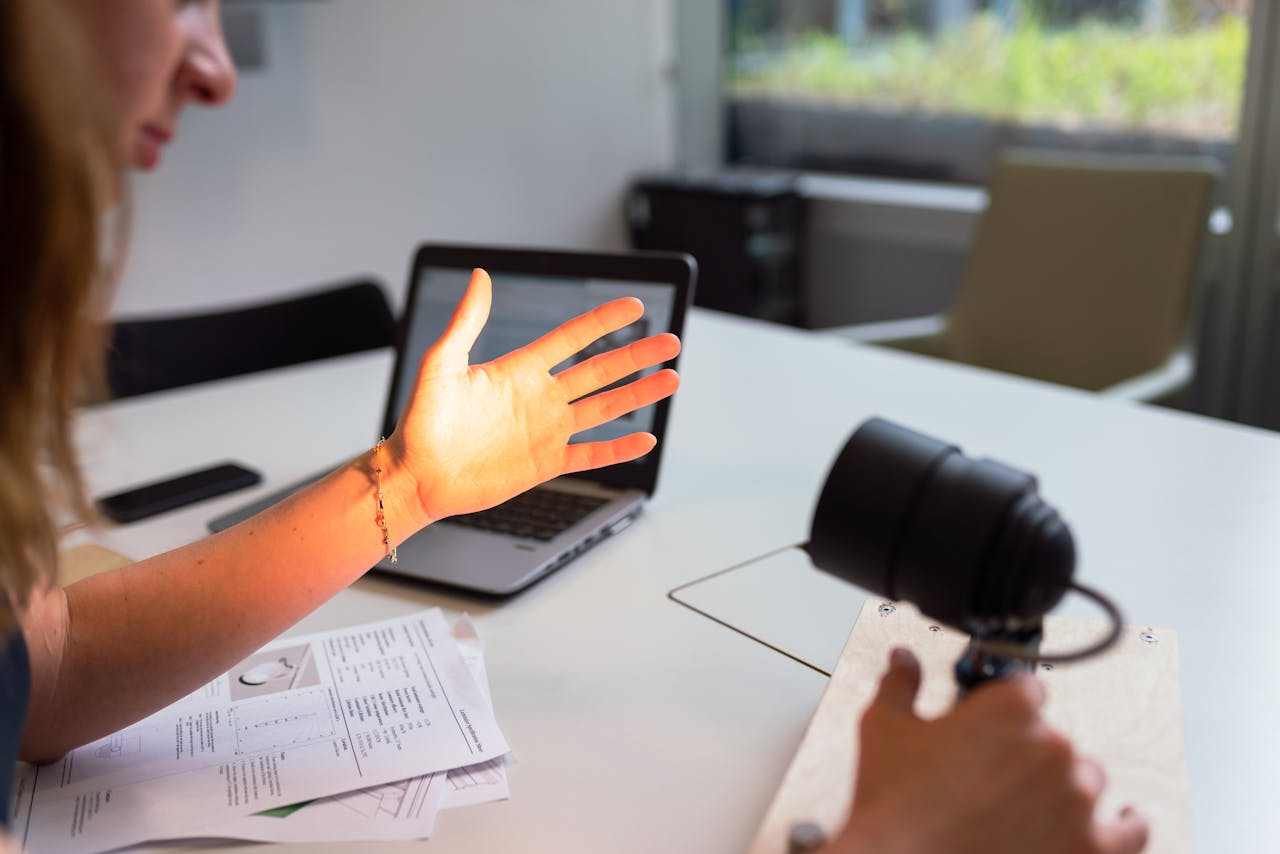 Female engineer tests lighting prototype on her hand in a modern office environment.